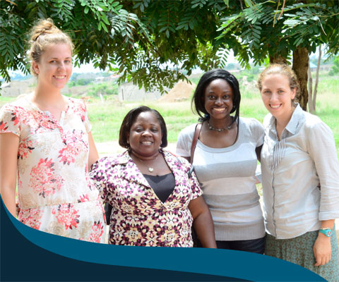 Students for Development interns with two local women in Africa.
