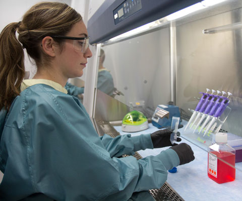 Jeune chercheuse travaille avec des éprouvettes dans un laboratoire.