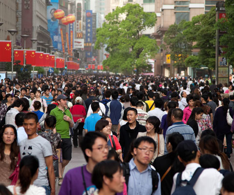 Une foule de Chinois marchent dans une rue.