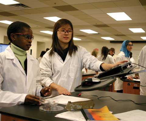 Two young female researchers working in a lab.