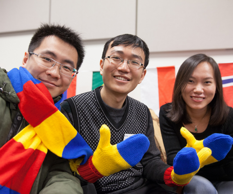 Three international students wearing winter gear in school colours