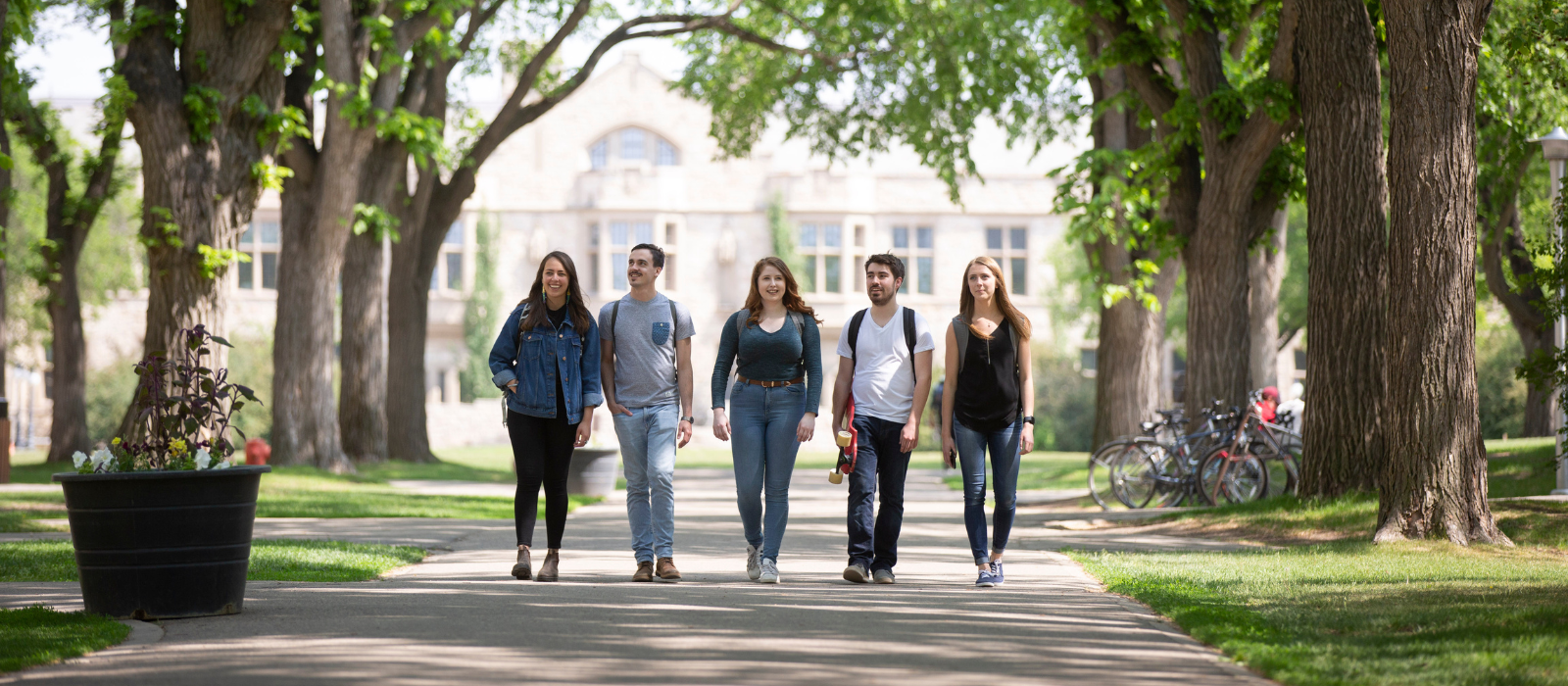 Five students walking away from a campus building