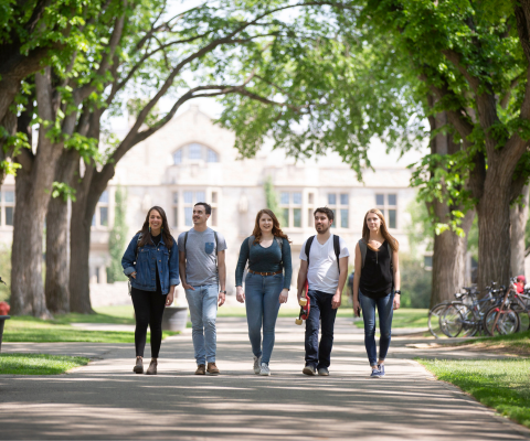 Five students walking away from a campus building